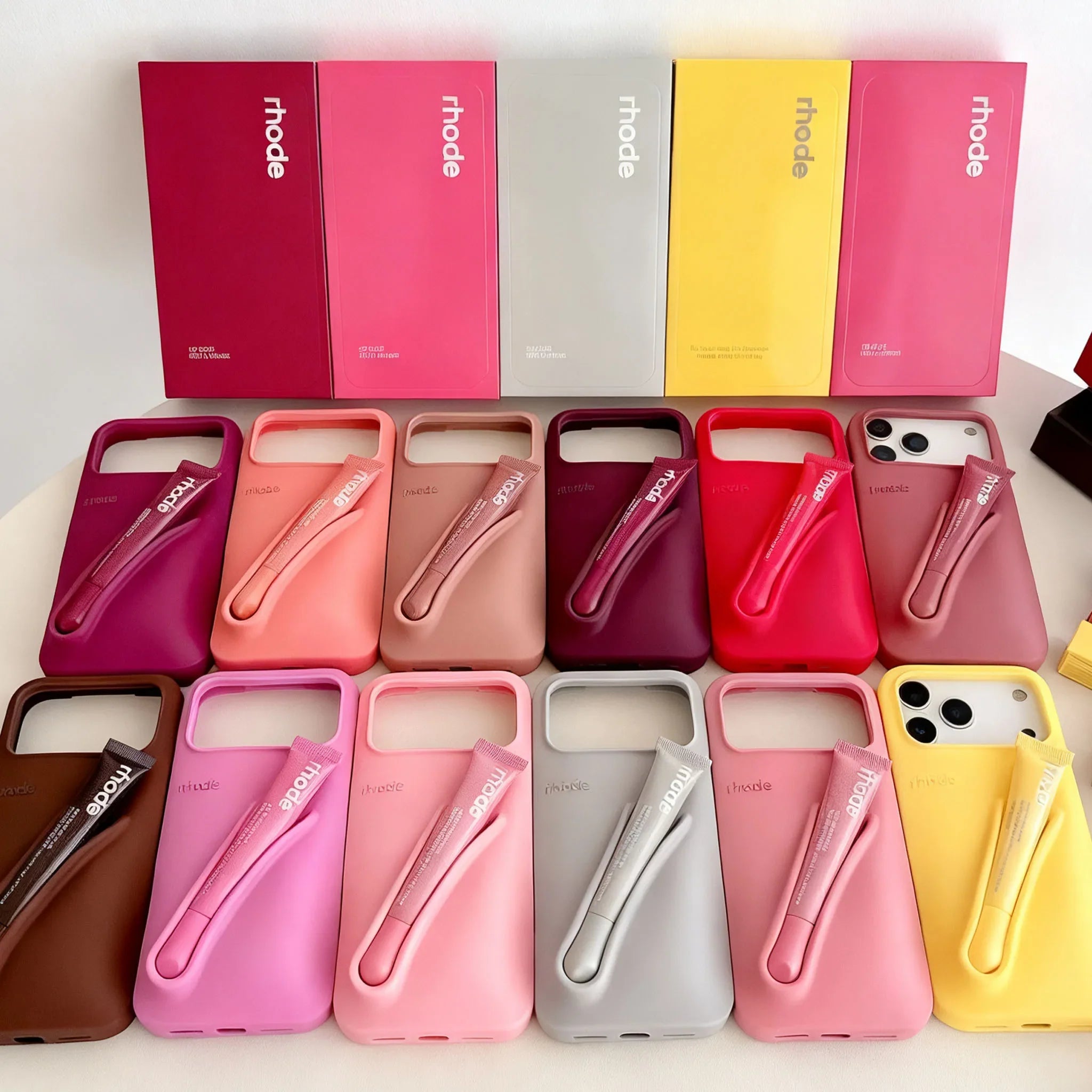 Collection of phone cases in various colors with 'rhode' branding.