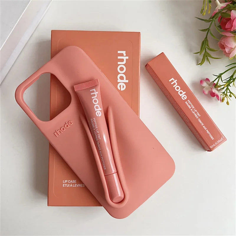 Pink lip case and lip balm with 'rhode' branding on a white background
