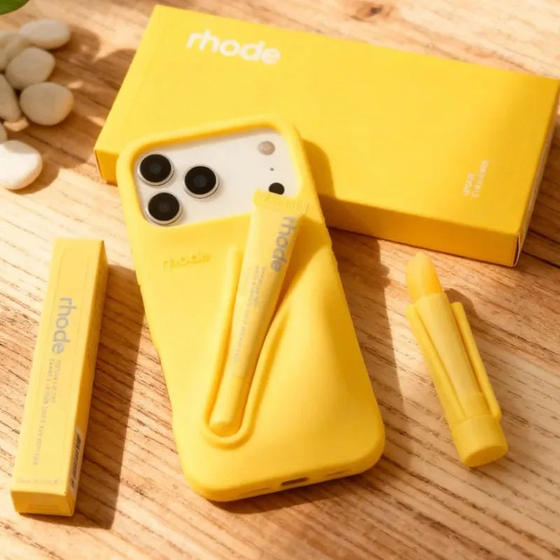 Yellow phone case with Rhode branding on a wooden surface