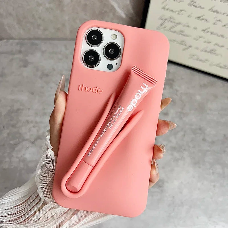 Pink phone Rhode case with a pen holder attached, held by a hand on a neutral background.