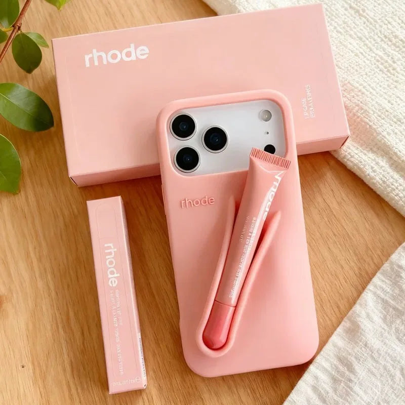 Pink phone case with pen holder and 'rhode' branding on a wooden surface.