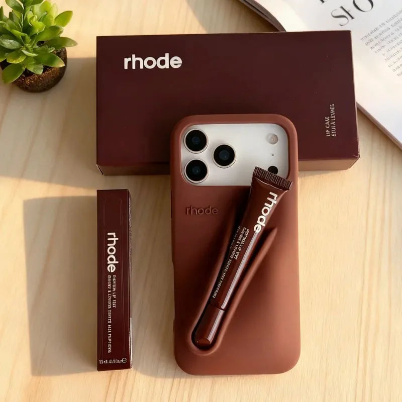 Brown Rhode phone case with pen holder and 'rhode' branding on a wooden surface.