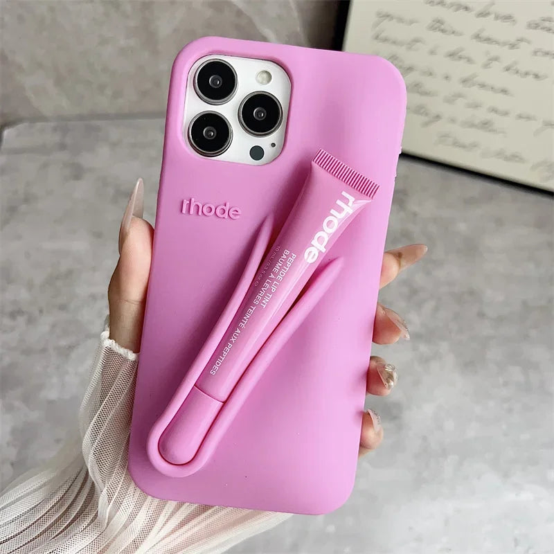 Pink phone case with a lip holder held by a hand on a neutral background