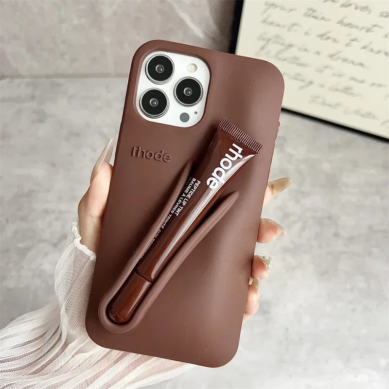 Brown Rhode phone case with a pen holder holding a pen, on a neutral background
