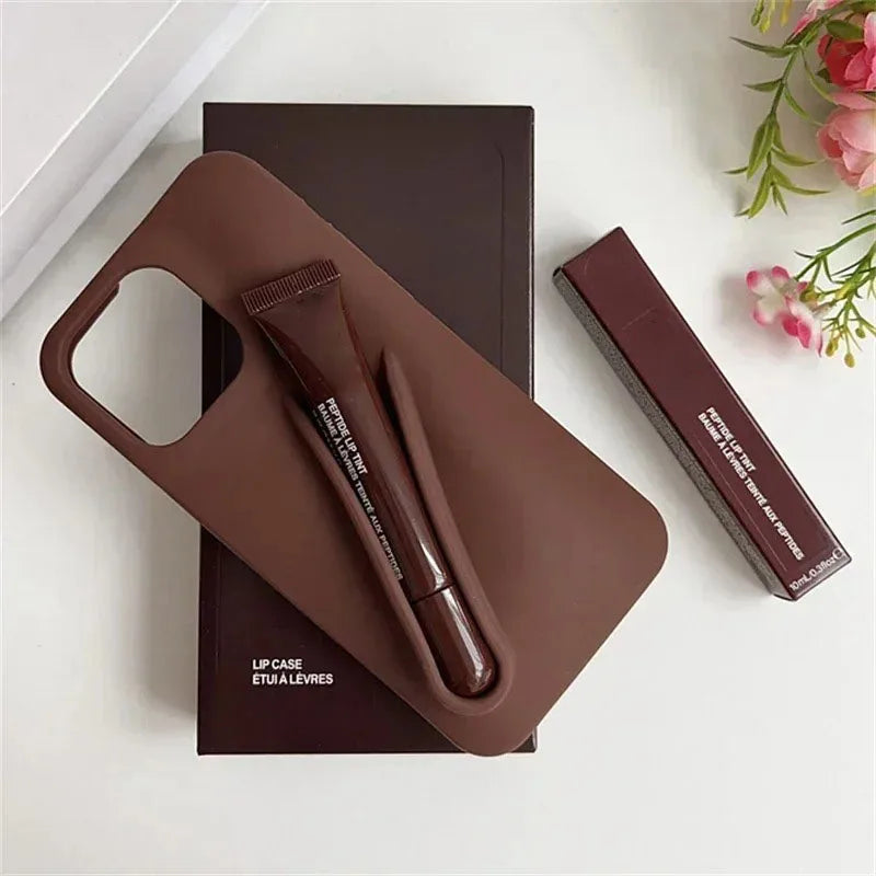 Brown Rhode lip case with applicator on a white surface with flowers in the corner