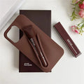 Brown Rhode lip case with applicator on a white surface with flowers in the corner