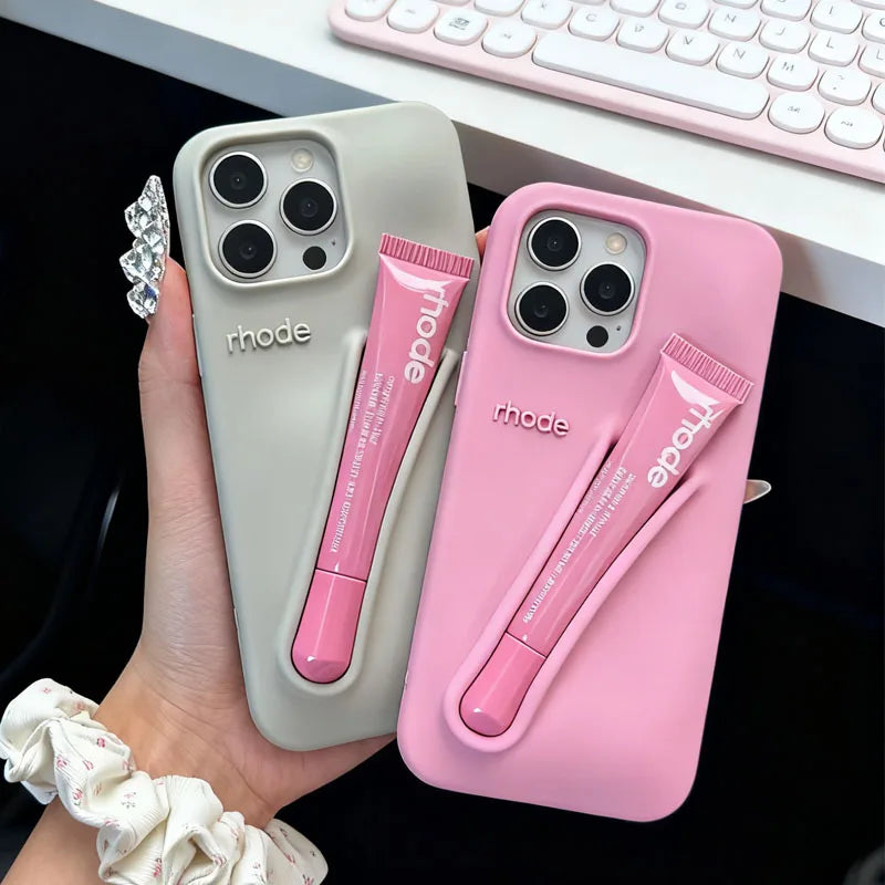 Two Rhode phone cases with a pen holder attached, one gray and one pink, held by a hand.