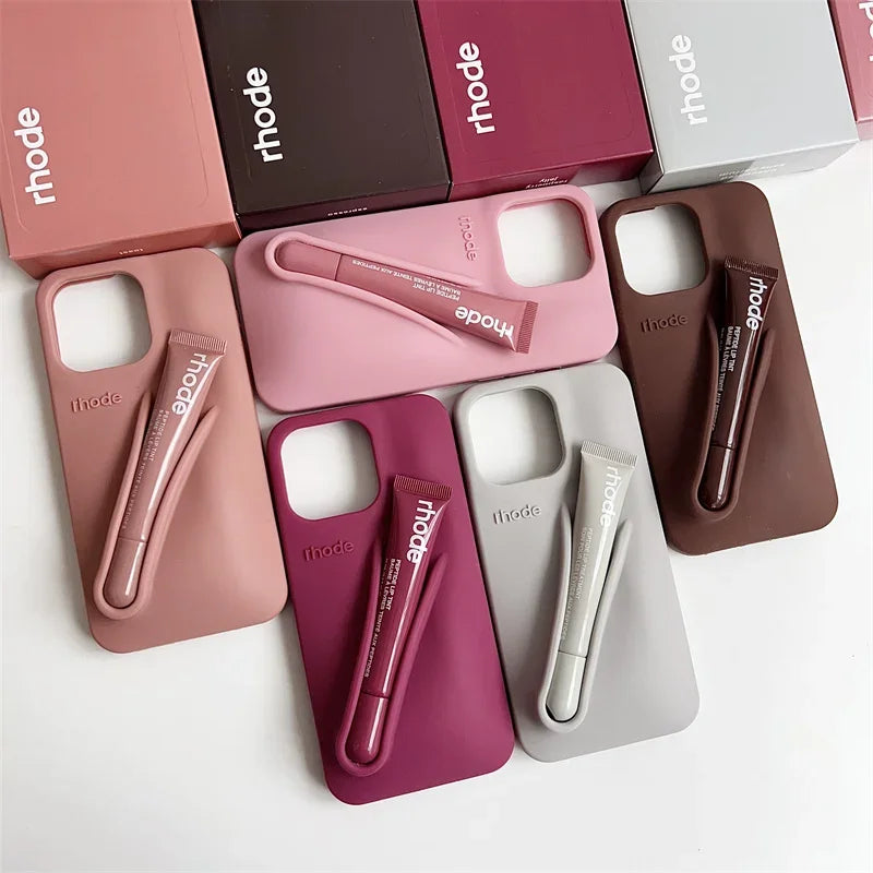 Collection of Rhode beauty products including phone cases and lip products on a white background.