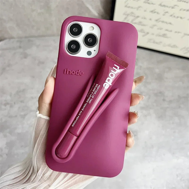 Pink phone case with a lip holder attached, held by a hand on a neutral background