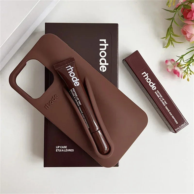 Brown Rhode lip case with lip balm and lipstick on a white surface with 'rhode' branding.