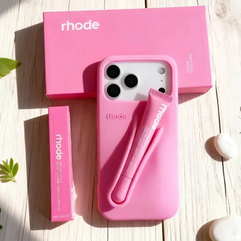 Pink Rhode phone case with 'rhode' branding on a wooden surface
