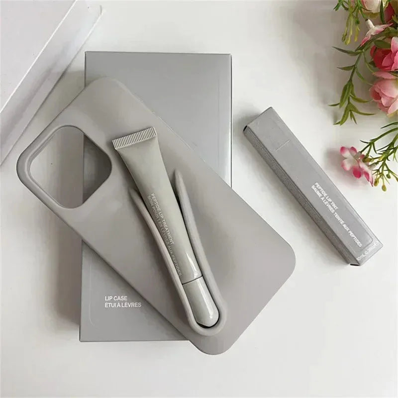 Gray Rhode lip care set with 'rhode' branding on a white surface with flowers in the corner.